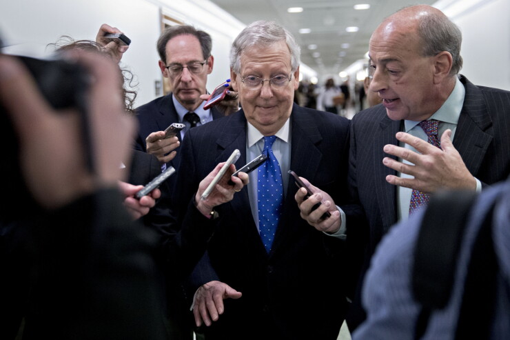 Senate Majority Leader Mitch McConnell, a Republican from Kentucky, center, walks through the Dirksen Senate Office building after speaking at a news conference on tax reform in Washington, D.C.