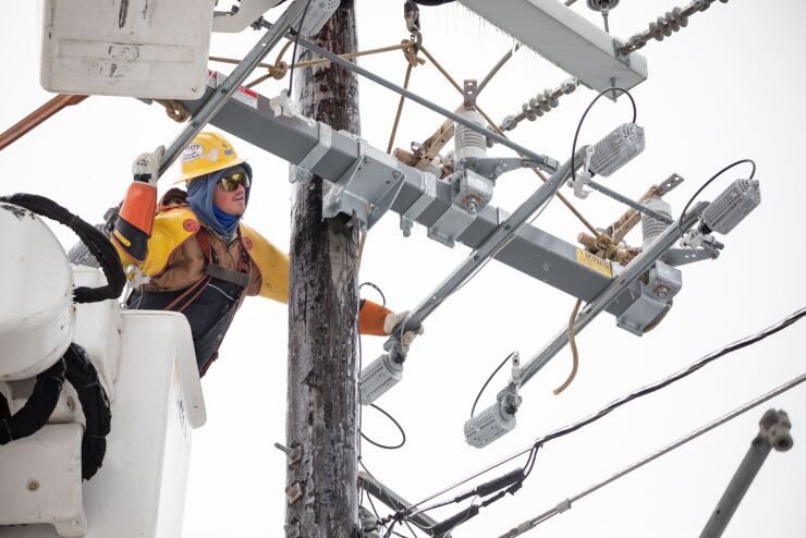 A utility worker repairs a power line