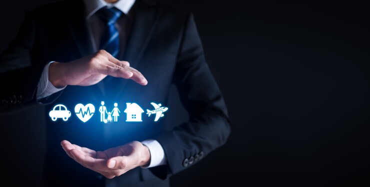 Businessman holding hands above and below virtual icons of a car, heart, family, house and plane.