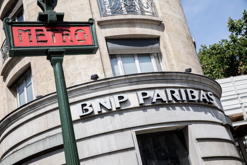 A BNP Paribas logo sits on display outside a bank branch in Paris.