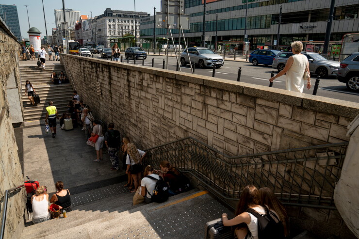 People wait in the shade during hot temperatures outside the Central Railway Station in Warsaw, Poland, on Aug. 5.