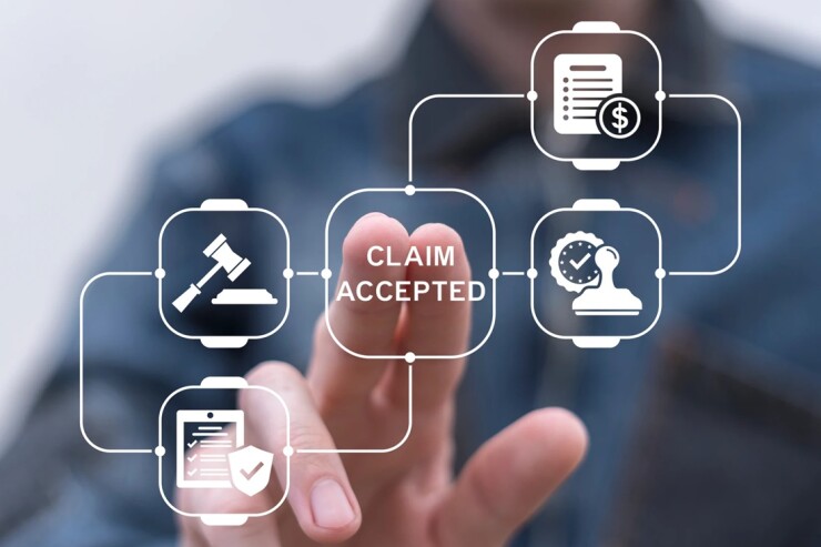 Person's fingers touching a button that says claim accepted.