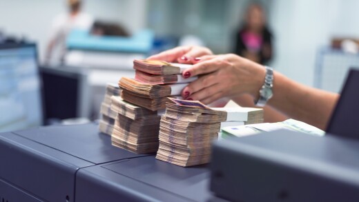 Bank employees sorting and counting money inside bank vault. Large amounts of money in the bank.
