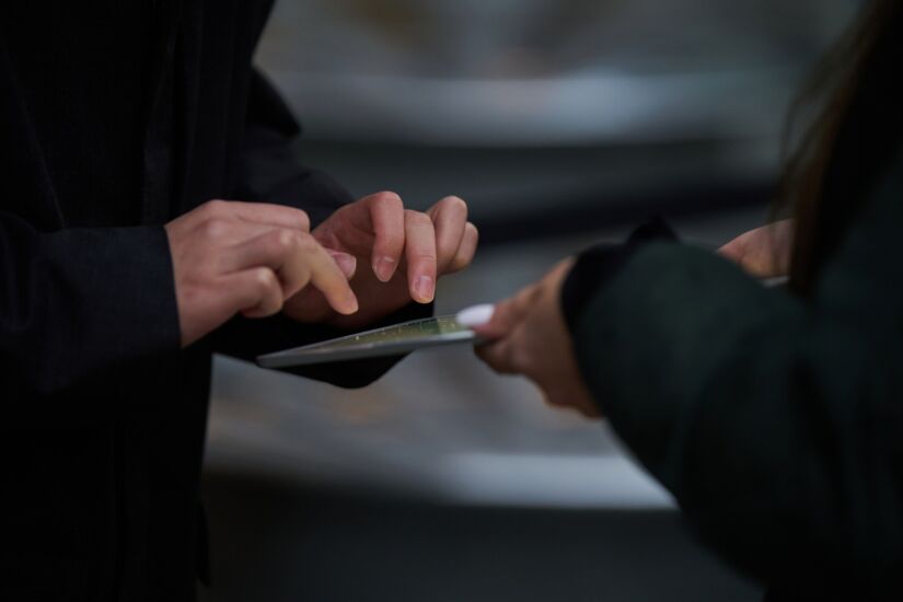 Customer using iPad held by employee