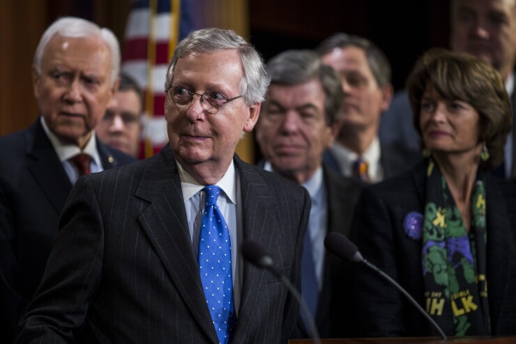 Both the Senate and House voted to pass a rewrite of the U.S. tax code that delivers a deep, permanent tax cut for corporations and shorter-term relief for individuals. Center: Republican Sen. Mitch McConnell of Kentucky.