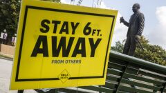 A sign reminding people to social distance stands at Louis Armstrong Park in New Orleans, Louisiana, U.S., on Wednesday, July 15, 2020. Many places that suffered most in the first wave of coronavirus infections including Louisiana are seeing case counts climb again after months of declines. Photographer: Sophia Germer/Bloomberg
