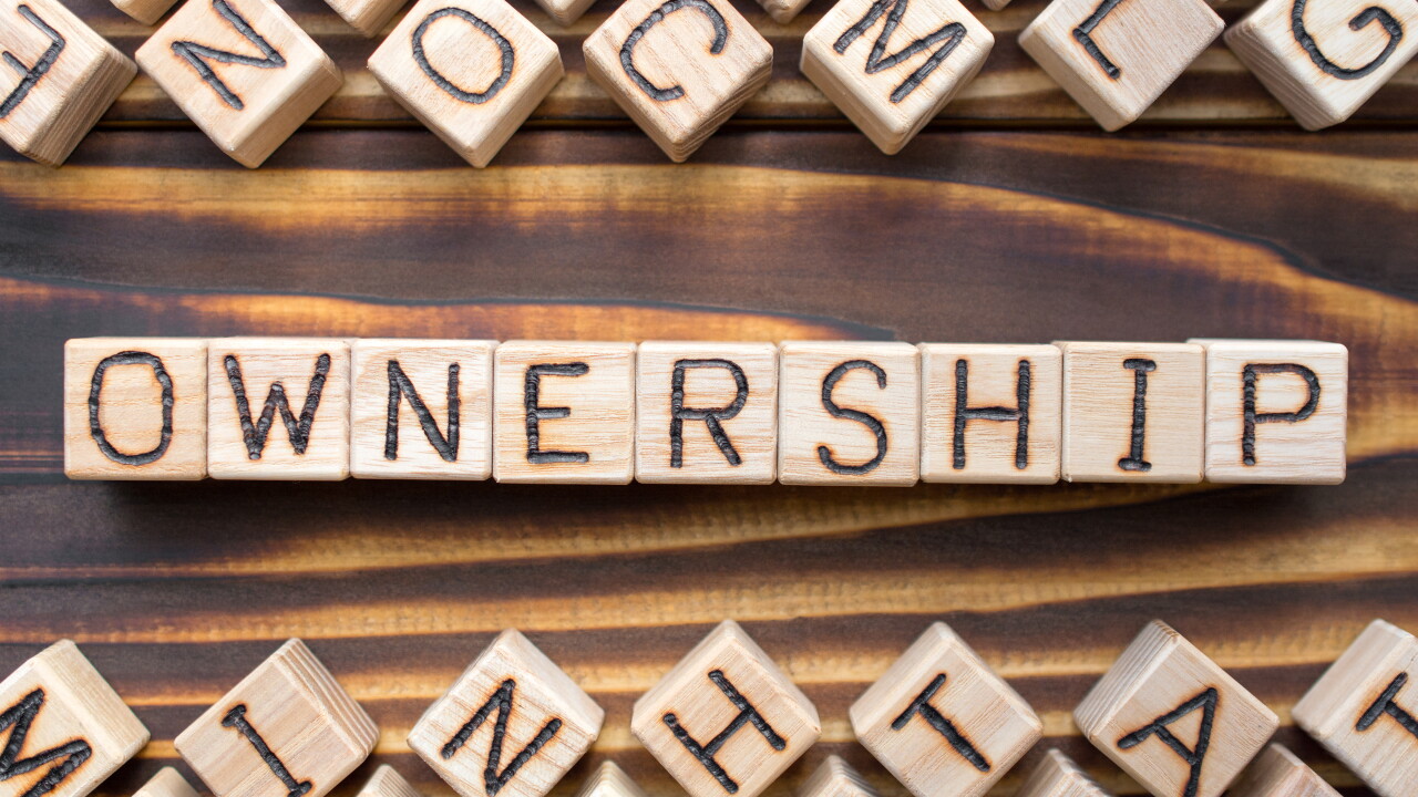 ownership wooden cubes with letters, legal property possession concept, around the cubes random letters, top view on wooden background