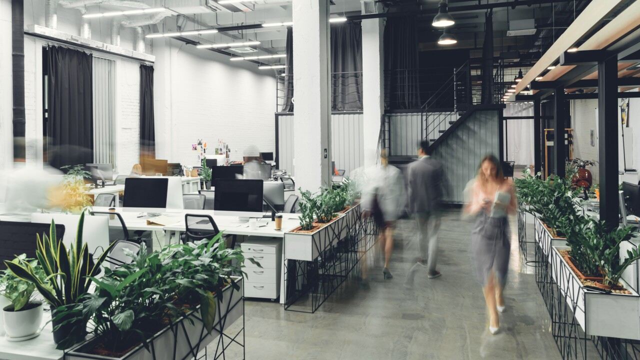An open concept office with blurred people walking.
