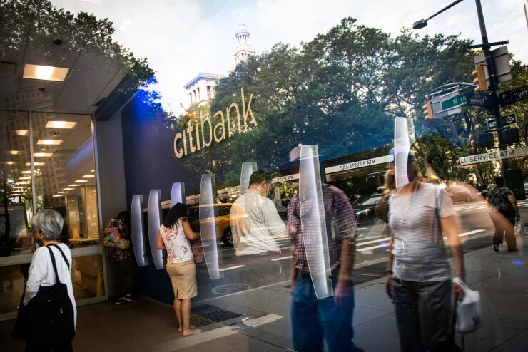 People use automated teller machines (ATM) as pedestrians are reflected on the window of a Citigroup Inc. bank branch in New York, U.S., on Wednesday, July 3, 2019. Citigroup Inc. is scheduled to release earnings figures on July 15. Photographer: Mark Kauzlarich/Bloomberg