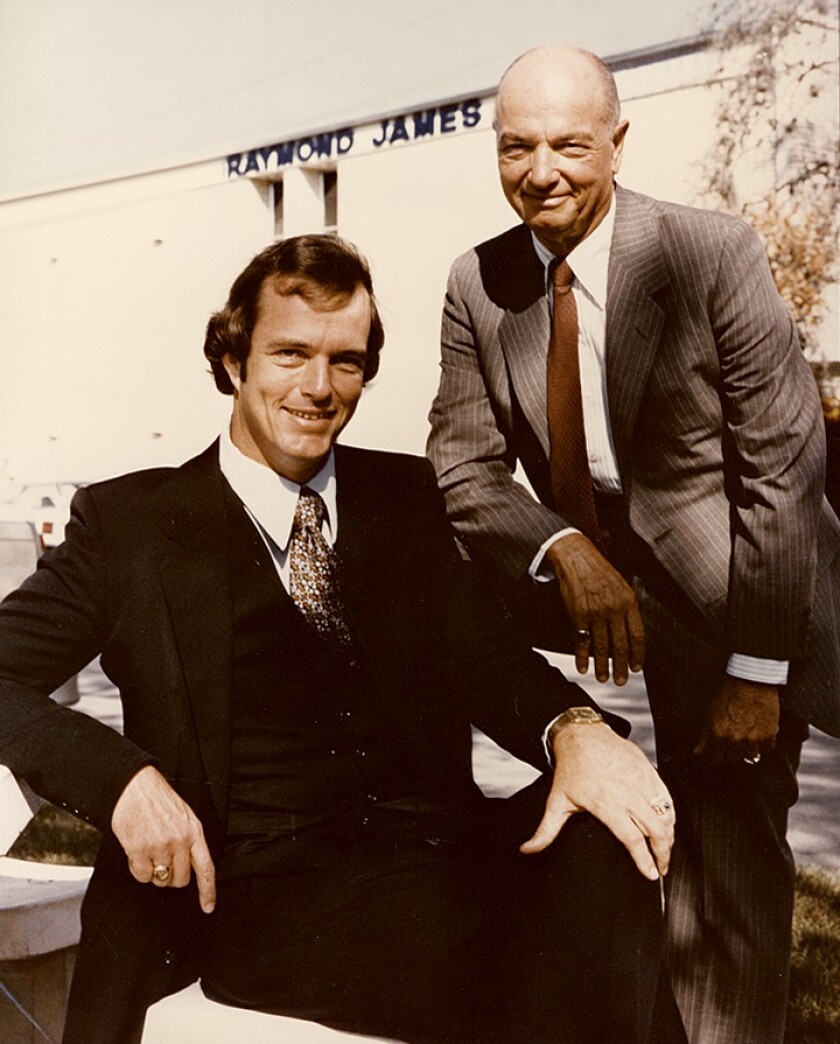 This photo of founder Bob James with his son, Tom, hangs in the St. Petersburg, Florida, headquarters of Raymond James.