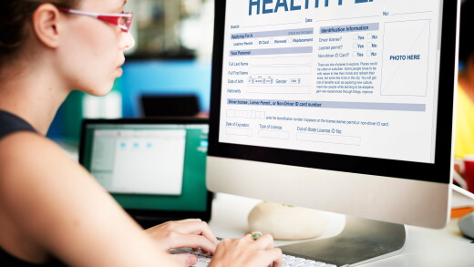 Woman looking at computer filling out healthcare plan information