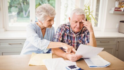 Worried senior couple checking their bills