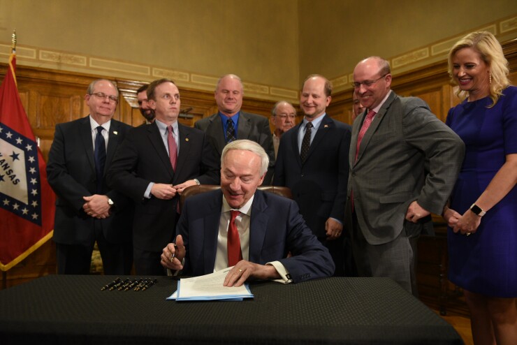 Arkansas Gov. Asa Hutchinson signs a bill March 12, 2019 raising the state’s gas taxes for the first time in 19 years.